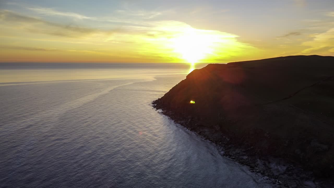 Aerial sunset time-lapse at the ocean with the sun setting in the ocean