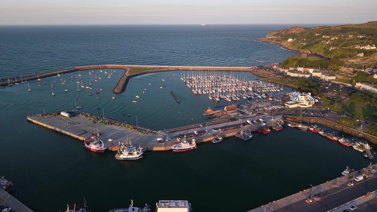 İrlanda, Howth Limanı sahil şeridinin güzel altın saatte manzaralı drone görüntüsü