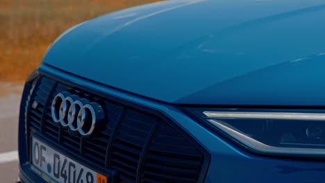 new audi e-tron electric car. front view of a modern metallic blue automobile moving on a road.
