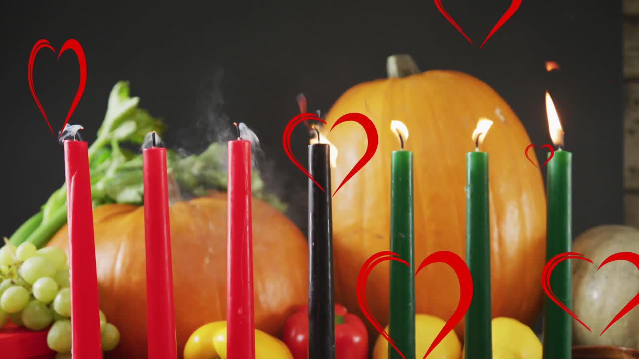animación de corazones rojos sobre velas kwanzaa y calabazas