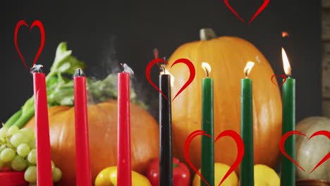 animation of red hearts over kwanzaa candles and pumpkins