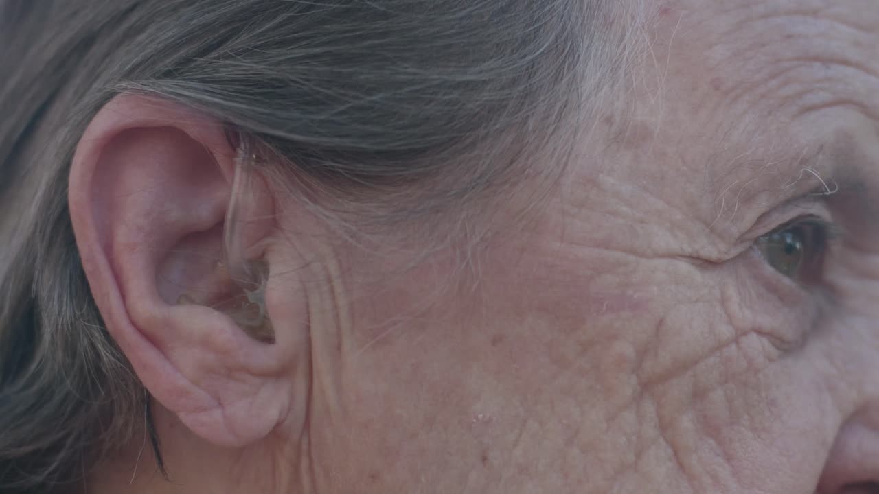 Elderly woman with a hearing aid