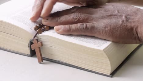 rezando a dios con la mano en la biblia con mesa blanca metrajes