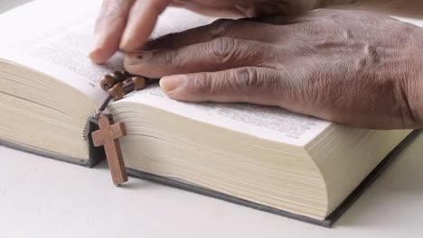 praying to god with hand on bible with white table stock footage