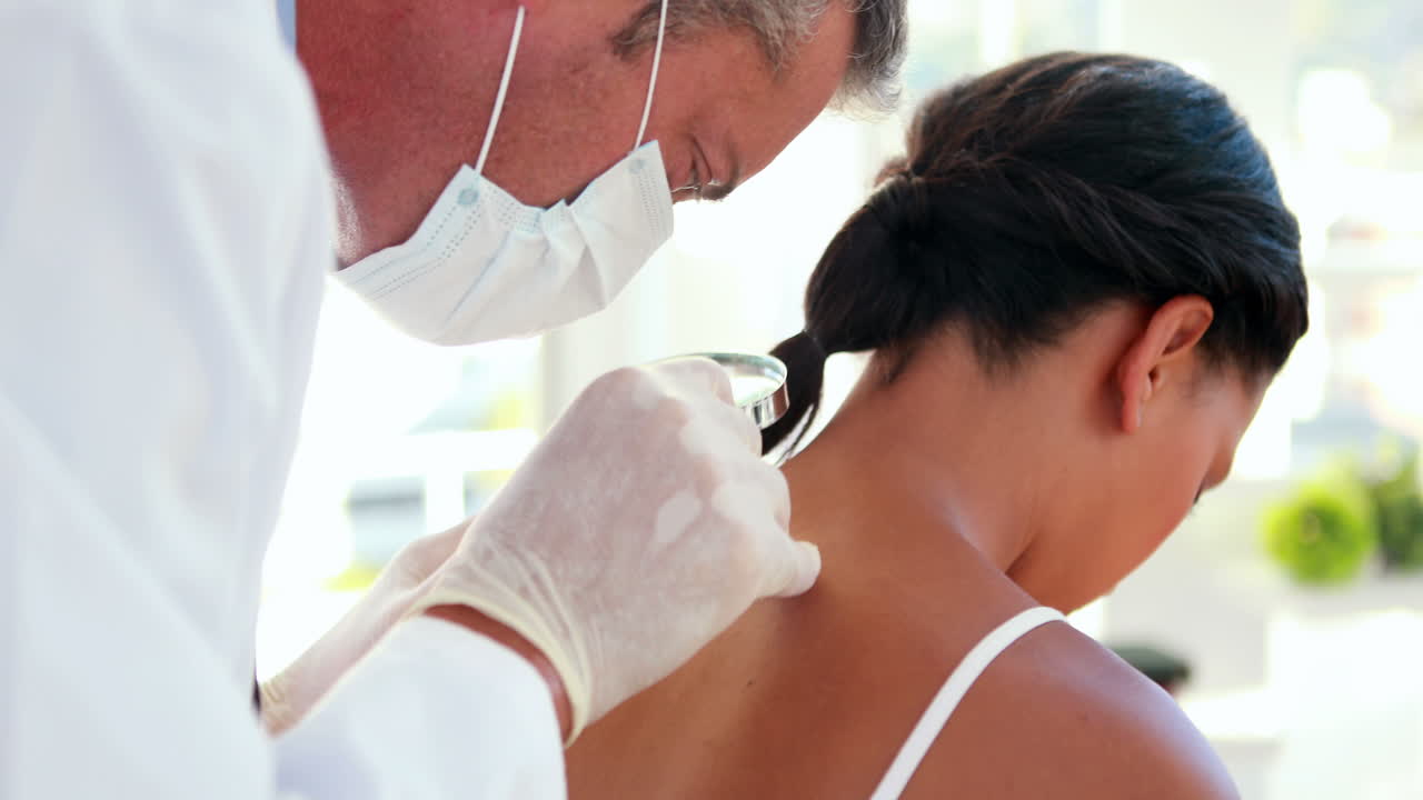 의사 는 환자 의 등 을 확대 유리 로 검사 하고 있다