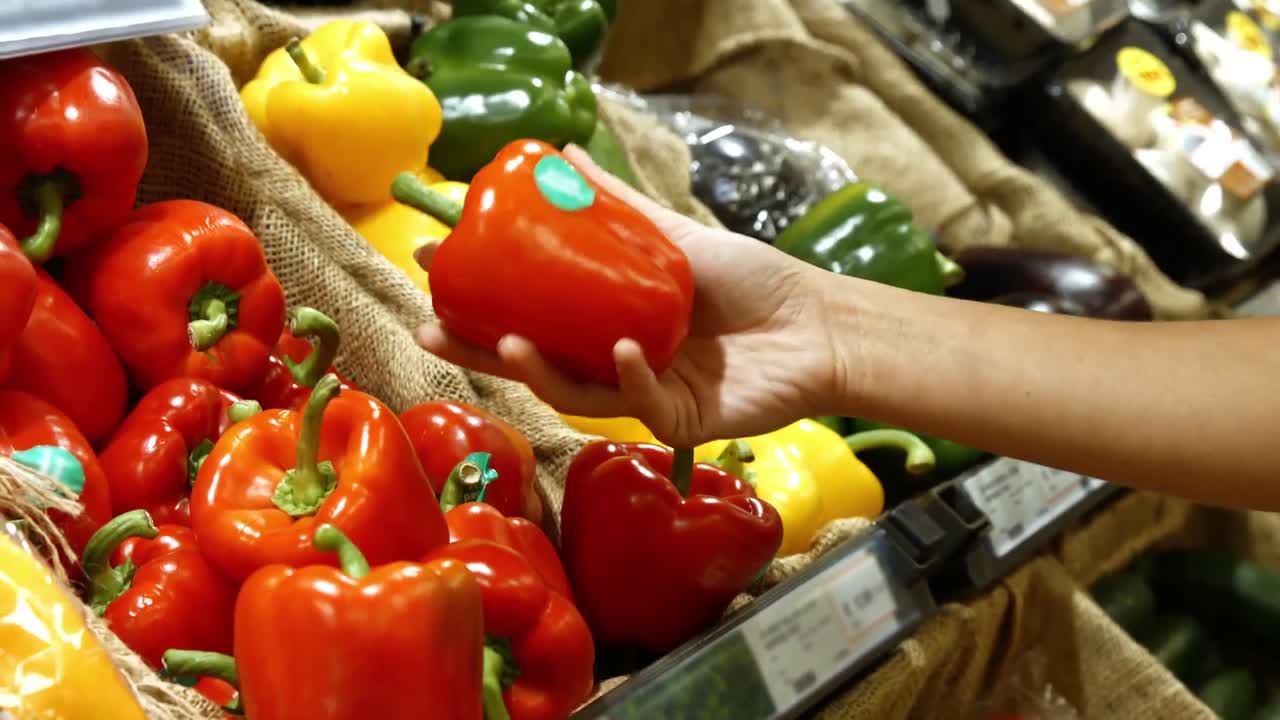 mujer comprando verduras en la sección orgánica