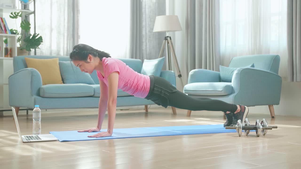家でプッシュアップをしている女性