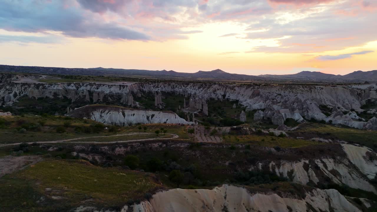 Aerial view over Cappadocia's rocky landscape during a vibrant sunset