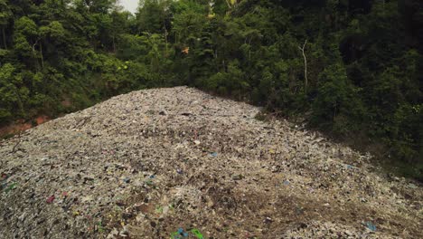 aerial diagonal tilt down shot of land fill garbage dump in the tropics in thailand