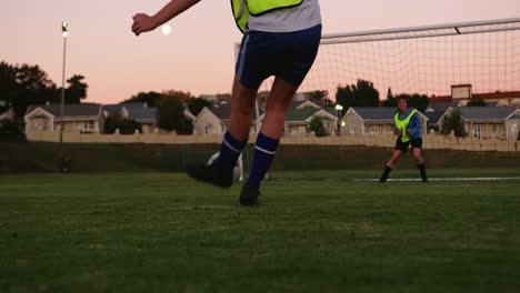 female soccer player scoring goal while keeper tries to catch it on soccer field. 4k