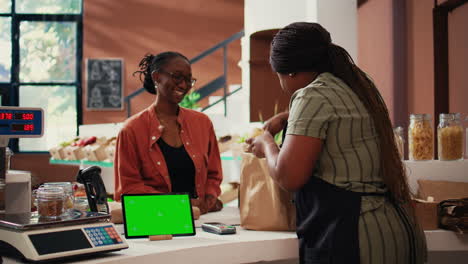 Customer-approaching-counter-with-greenscreen-on-device