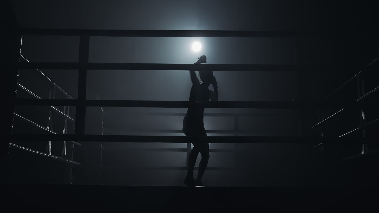 Silhouette di un pugile che si allena in un ring scuro