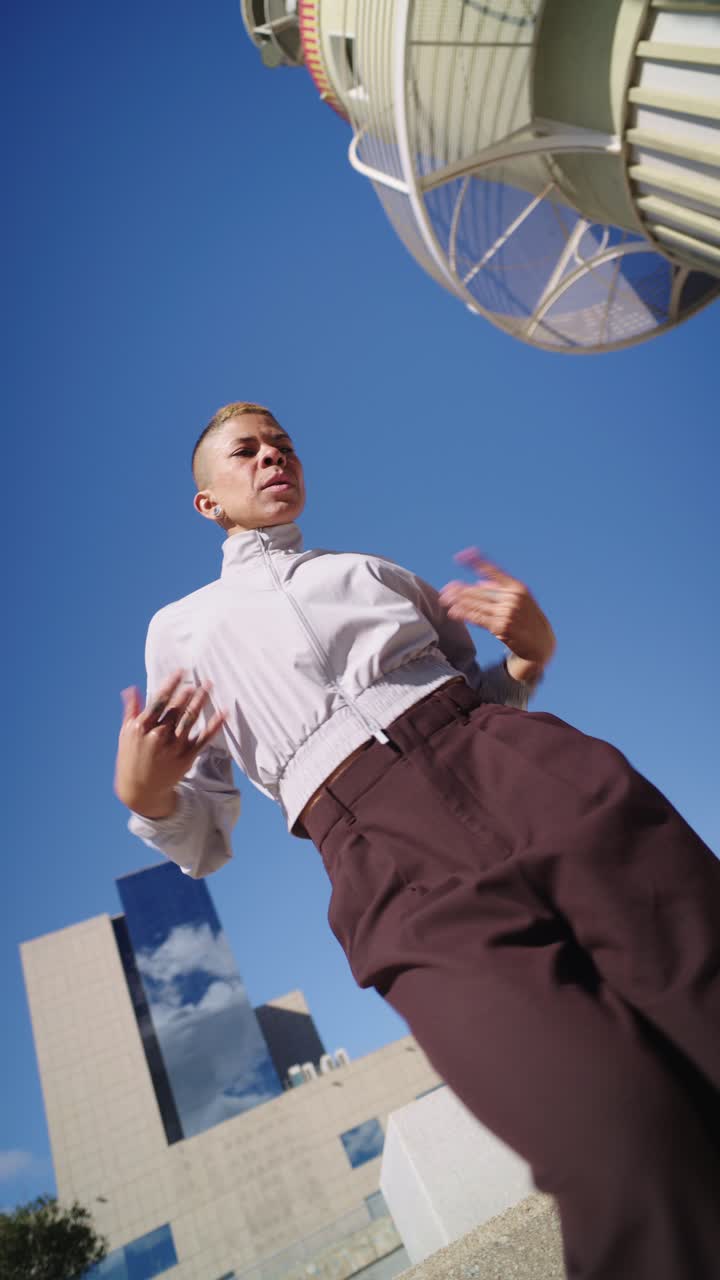 Expressive Dancer Moving Under a Clear Blue Sky in the City