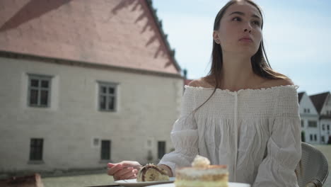 woman enjoying cake in an outdoor cafe