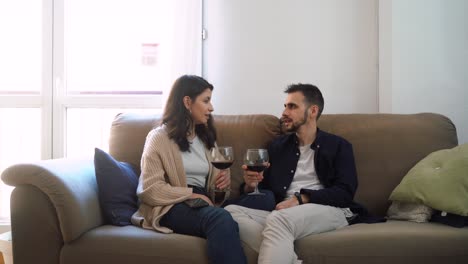 pareja sonriente con copas de vino en casa