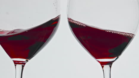 cheering red wine glasses closeup. alcohol rose drink clinking toasting goblets