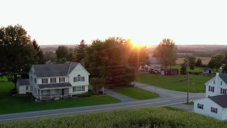 aerial establishing shot of two story home in country at sunset, sunrise