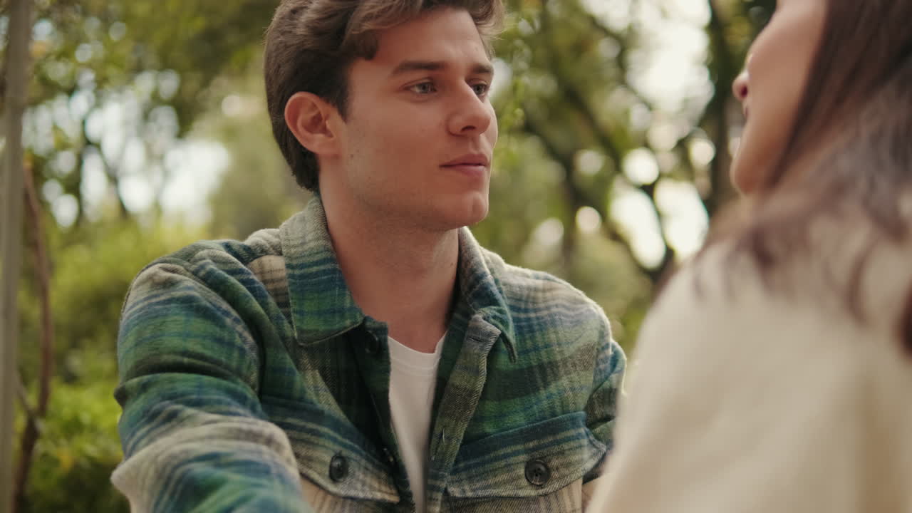 Close-up of young smiling man looking at his girlfriend