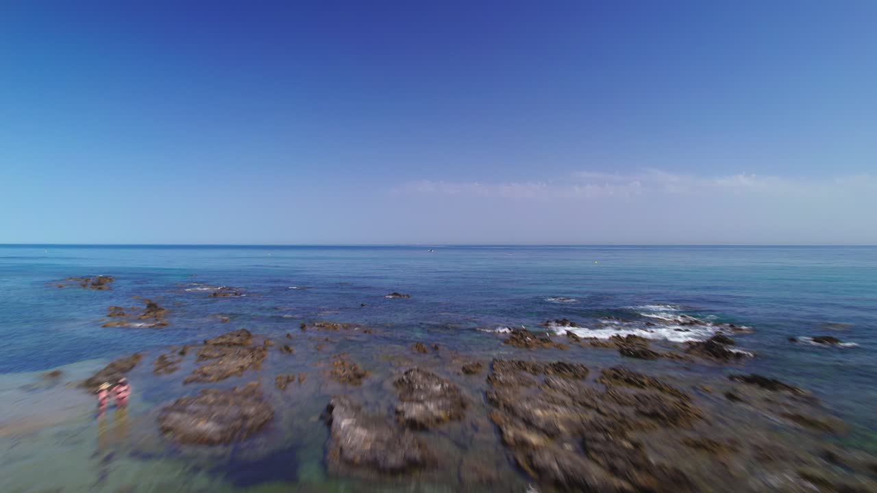 맑고 푸른 하늘을 배경으로 해변을 날고 있는 드론