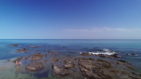 drone volando en la playa con un cielo azul claro