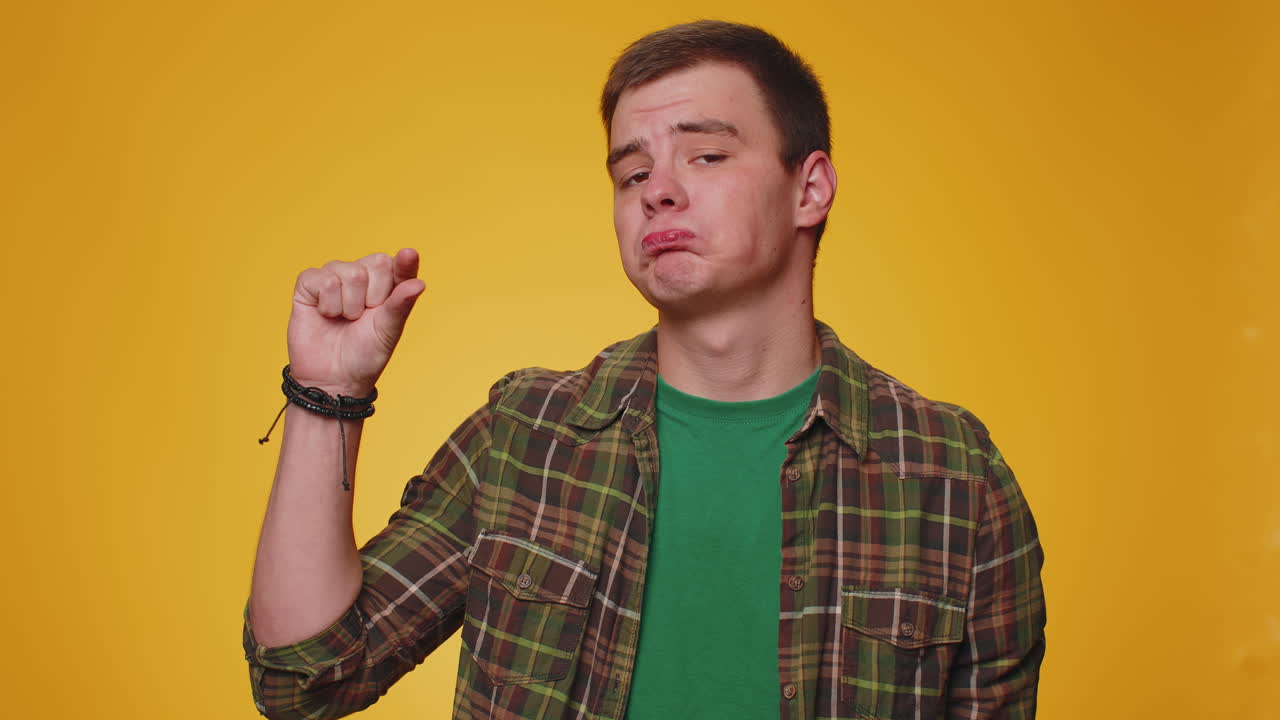 의심스러운 미소와 함께 약간의 몸짓을 보여주는 남자, 최소한의 표시를 보여주는, 작은 크기를 측정