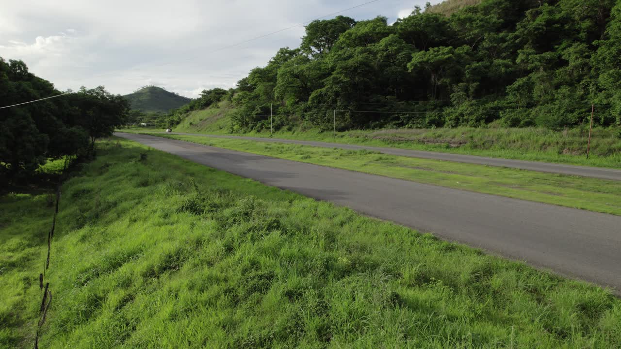 White truck driving along a highway surrounded by dense forest, Rio Verde, Venezuela