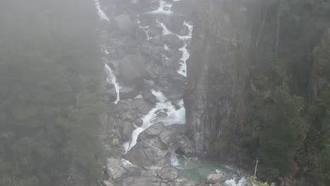 Drohne-Fliegt-über-Berggipfel-Und-Wildwasser-Mitten-Im-Wald---Drohnenansicht