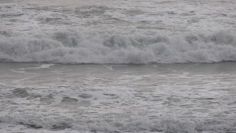 waves crash against beach on stormy day