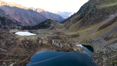 lake saussat leading to lac d'espingo mountain lake located in haute-garonne, pyrénées, france, aerial flyover approach shot