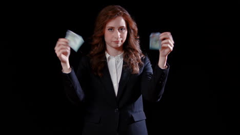 a caucasian businesswoman tears a dollar bill in half