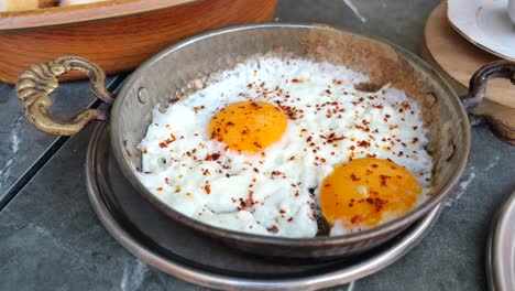 dos huevos fritos con escamas de pimienta roja para el desayuno turco