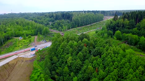 road and railroad intersection with forest and construction