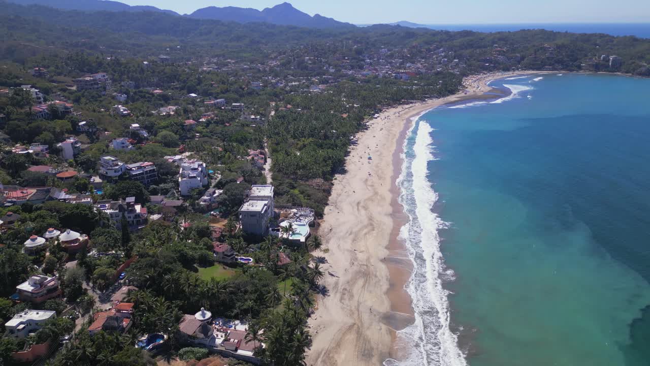 un dron se eleva hacia el cielo y desciende hacia la playa y el océano con la ciudad de sayulita méxico