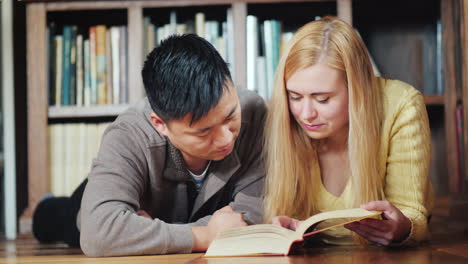 dos estudiantes leen un libro en la biblioteca 01