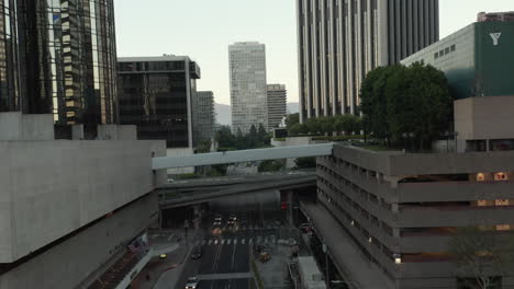 Bridges-and-pedestrian-overpasses-in-Downtown-Area-of-Los-Angeles-Big-City-in-Urban-Canyon-full-of-Buildings-and-Car-Traffic,-Aerial-Wide-View-backwards-dolly-out