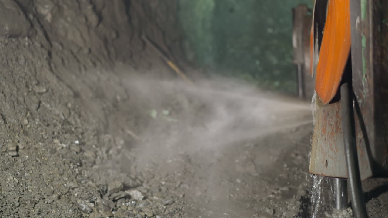 냉각액과 로 ⁇  드릴을 가진 무거운 기계가 광산에서 작동합니다.