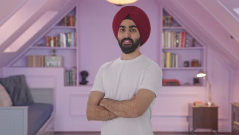 portrait of happy sikh indian man standing crossed hands