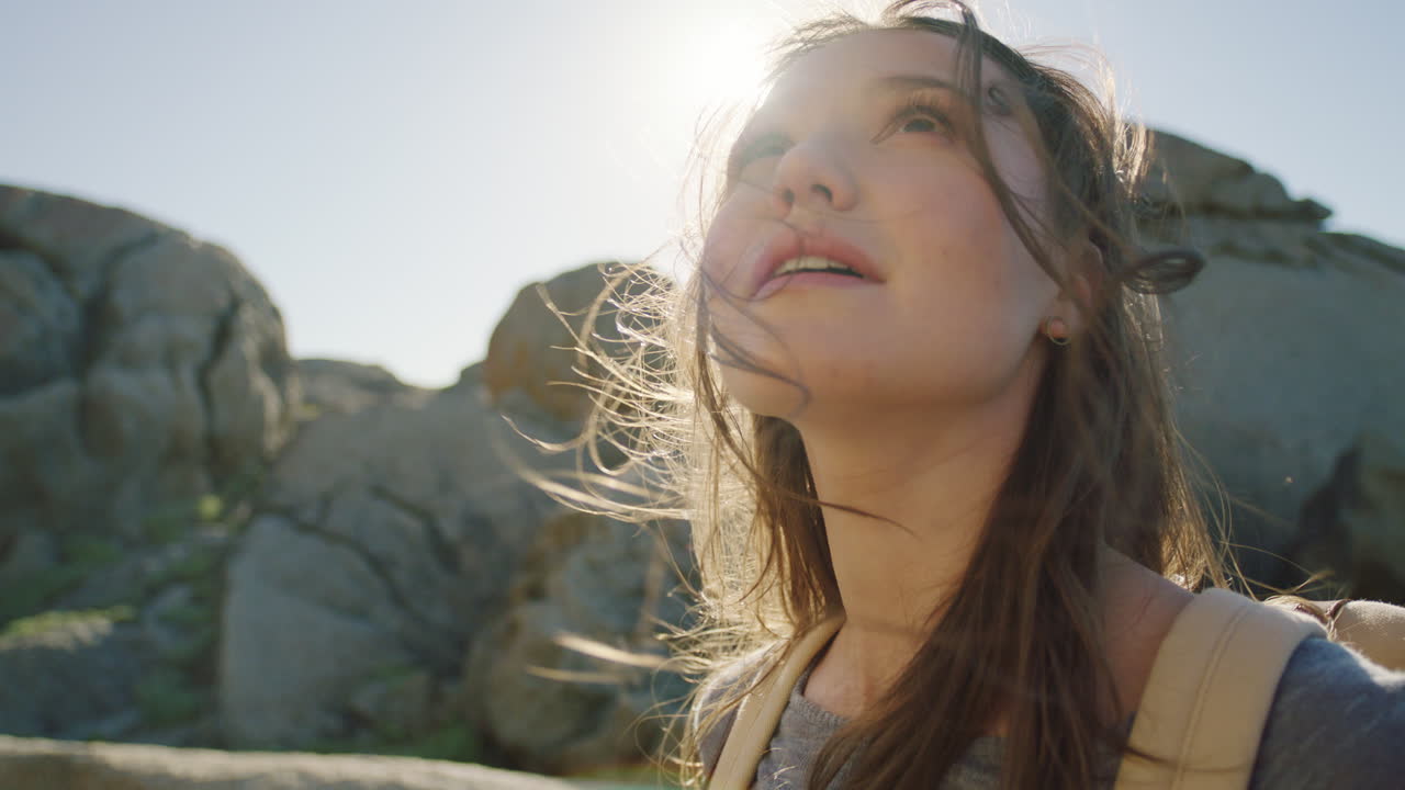 여자, 바람이 부는 해변과 하늘을 보는