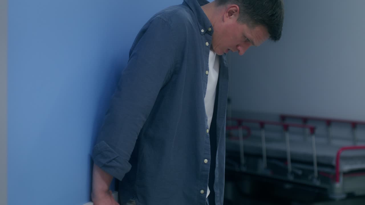 병원 벽 에 기대어 있는 우울 한 남자