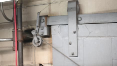 vista de derecha a izquierda de una puerta blindada de seguridad industrial en un taller de soldadura