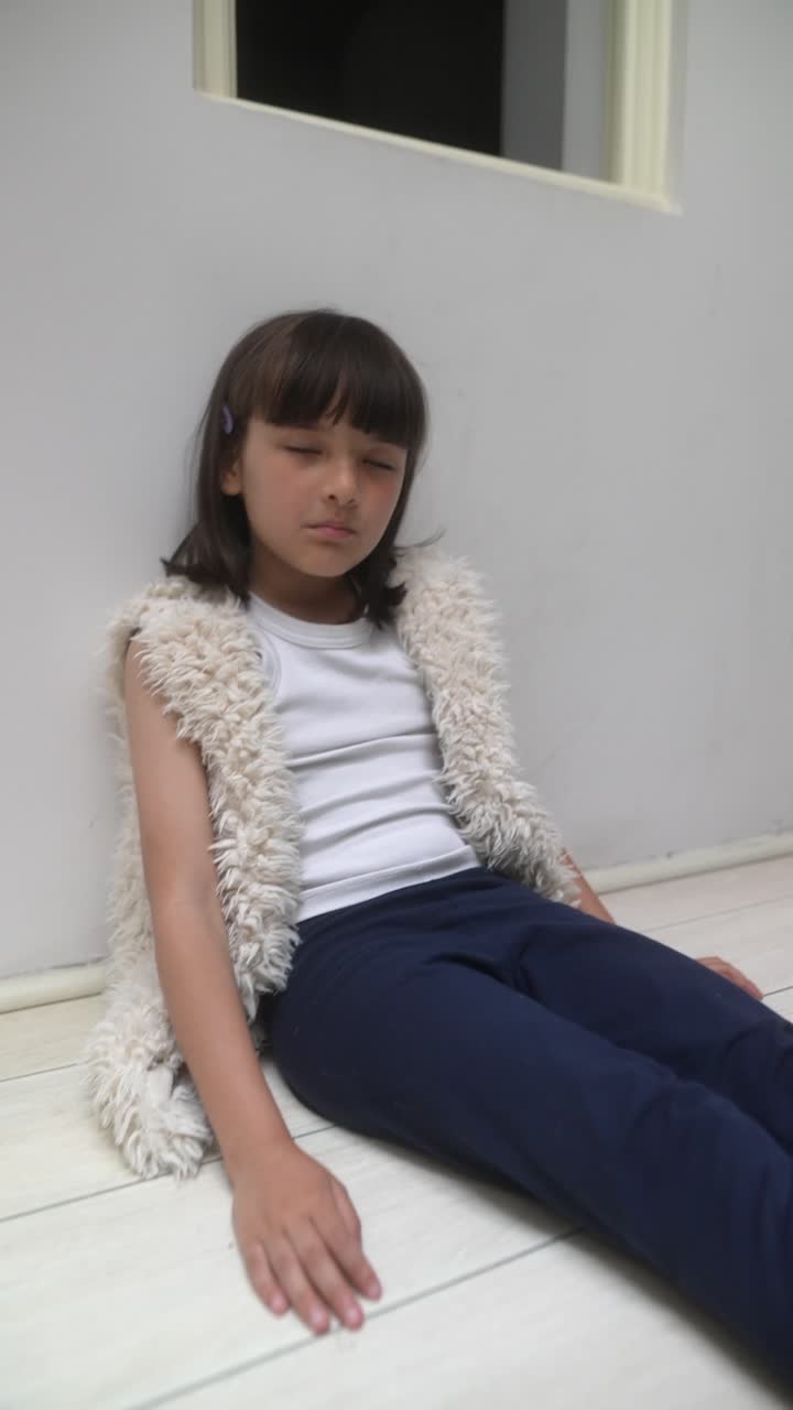 Una chica joven sentada en el suelo.