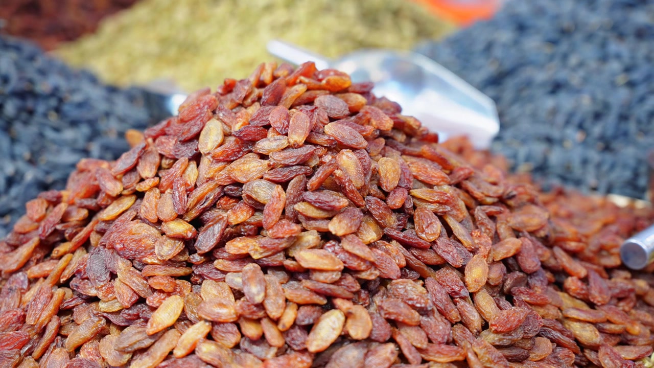 Fruits secs variés du Xinjiang exposés dans une boutique de spécialités locales Piles de raisins secs multicolores et jujubes de Yining, Chine Vue rapprochée de snacks naturels à base de baies et de raisins secs