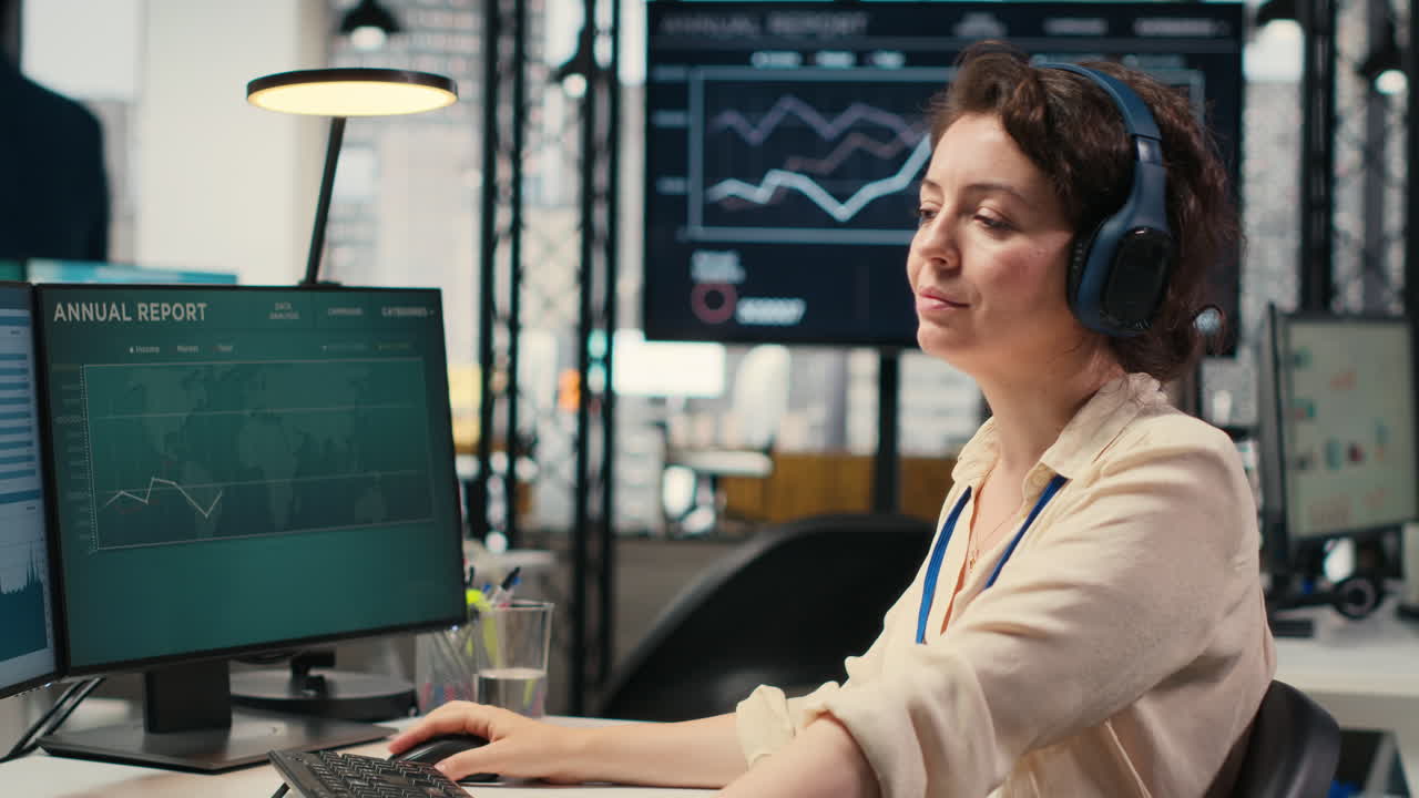 Vertical Video Young businesswoman focused on a podcast while she resolves office tasks