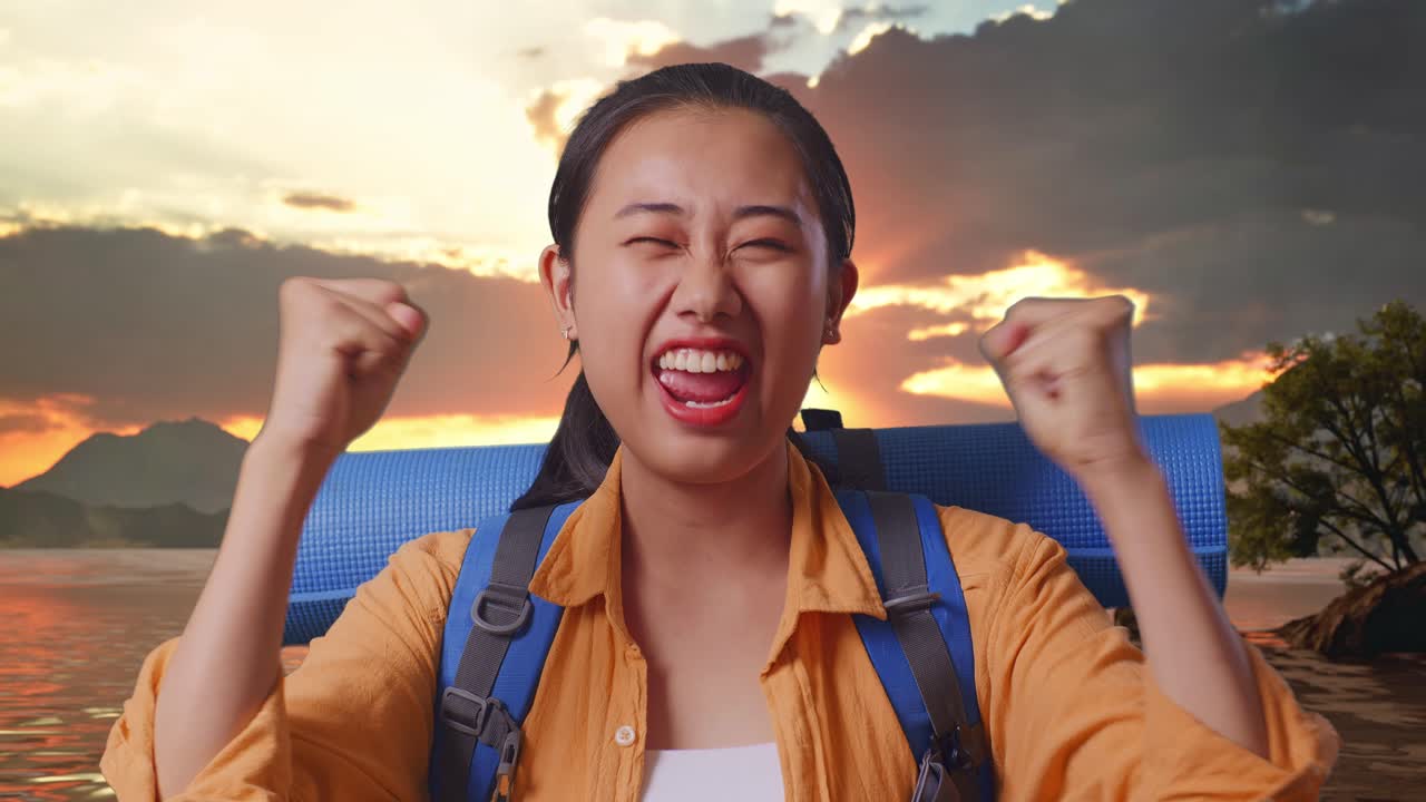 Close Up Of Asian Female Hiker With Mountaineering Backpack Screaming Goal Celebrating The Success While Standing At A Lake During Sunset Time