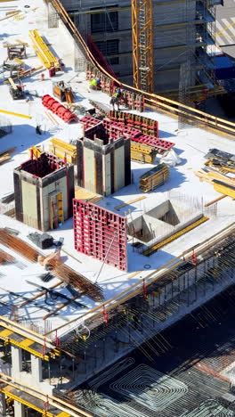 urban construction activity. workers are busy on a large construction site with cranes, scaffolding, and building materials during daylight
