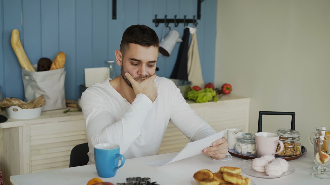 Man Reading Document in Kitchen
