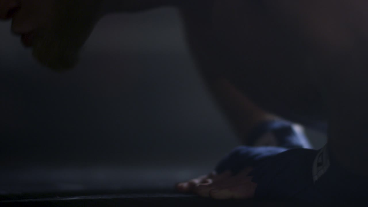 Man doing push-ups with boxing wraps