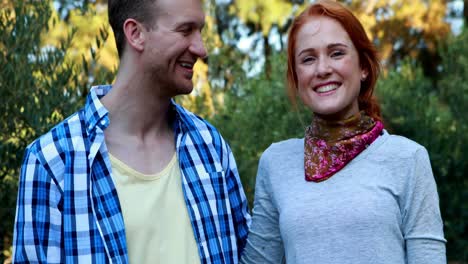 retrato de una pareja sonriente de pie con el brazo alrededor