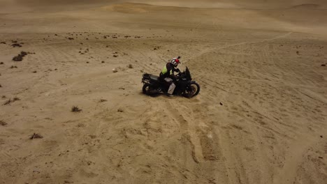 motorcyclist stuck in the sand of a steep hill or dune in the desert