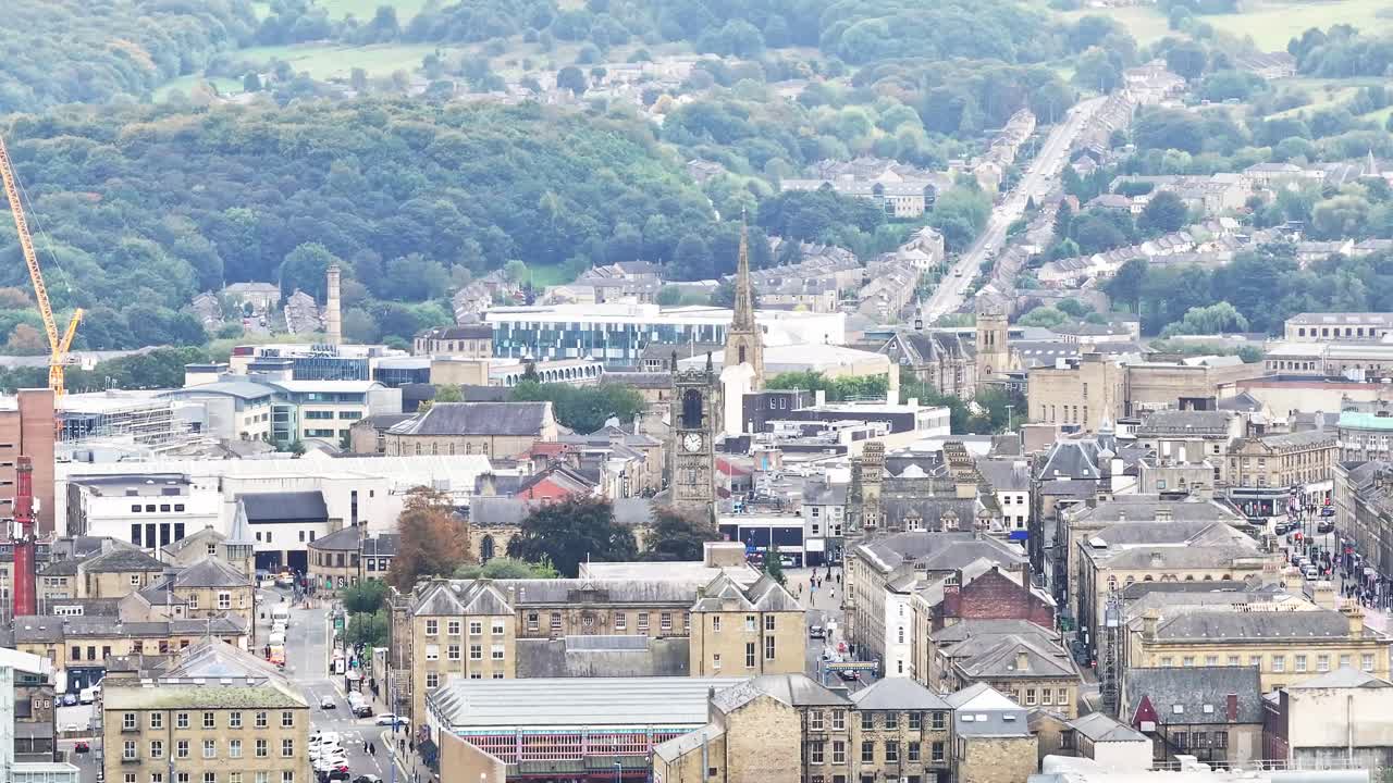 la histórica torre del reloj de roca y el campanario de la iglesia entre la zona industrial de huddersfield